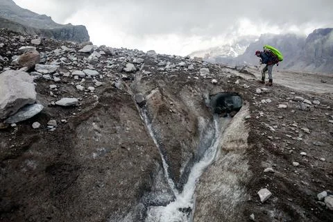 A powerful glacial river cuts through the rugged terrain, carving deep gorg.. Stock Photos