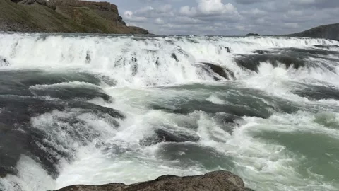 Powerful glacial waters of Gullfoss waterfall plunge over rugged volcanic cliffs Stock Footage 312232917