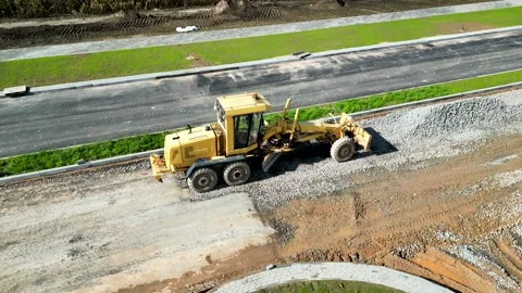 A powerful grader is leveling the road at a construction site. Stock Footage 218732884
