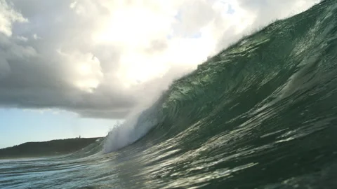 Powerful Green Ocean Wave Curling Beneath Bright Clouds Near Water Level Stock Footage 344385915