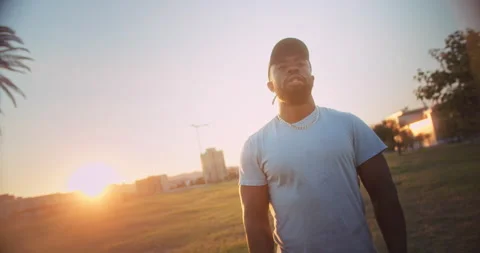 Powerful handsome black man standing at city park resting calmly at morning Stock Footage 140739480
