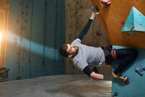 Powerful handsome boulderer without forearm training at climbing gym Stock Photos