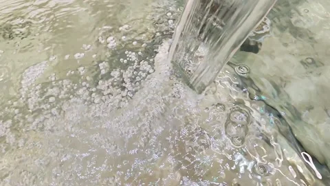 A powerful jet of liquid falls into a transparent aquarium Stock Footage 174160841