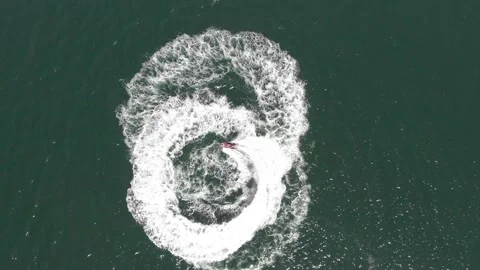 Powerful jet ski makes a figure-eight pattern in the water as an overhead Stock Footage 201122052