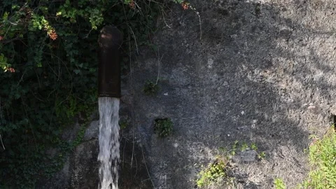 Powerful jet of water comes out of a large iron pipe, slow motion. Stock Footage 158835945