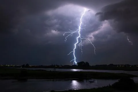 Powerful lightning bolt strikes down near a river Stock Photos