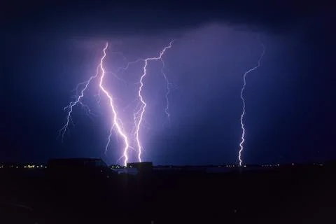 Powerful lightning bolts strike down from a storm Stock Photos
