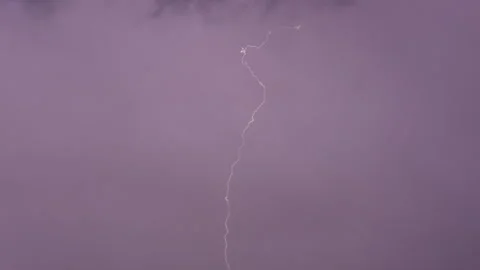 A powerful lightning strike flashes vividly against a pitch black night sky.. Vidéo 337457348