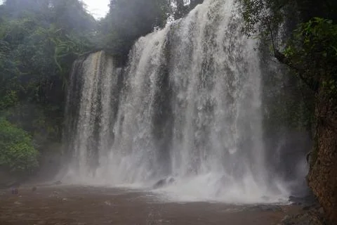 Powerful Main Waterfall Cascading into Misty Pool at Phnom Kulen, Cambodia Stock Photos
