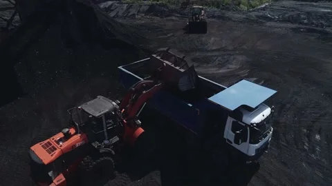 A powerful mining loader loads a heavy dump truck with coal ore. Close-up video Video stock 169590095