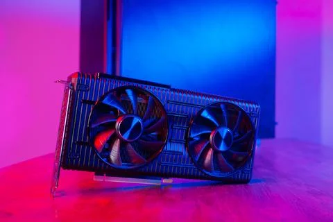 Powerful modern GPU Video Card with two fans with PC case on background in neon Stock Photos