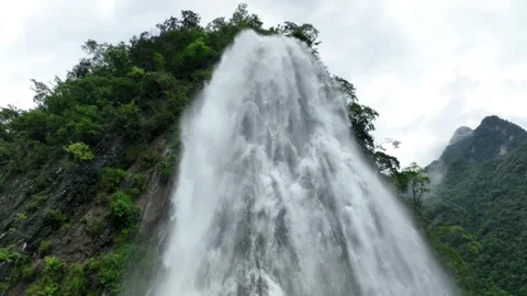 Powerful mountain waterfall cascading down a steep rocky cliff face in daylight 스톡 동영상 342108967