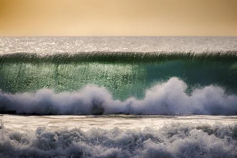 Powerful ocean wave cresting with translucent green water and white foam at.. Photos