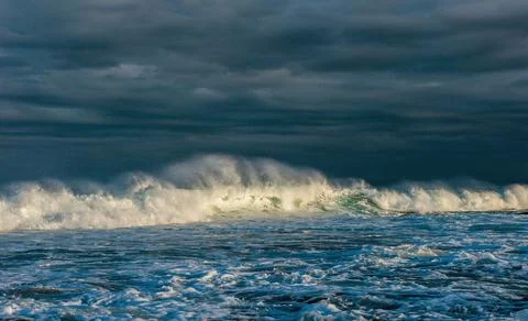 Powerful ocean wave on the surface of the ocean. Wave breaks on a shallow ban Stock Photos