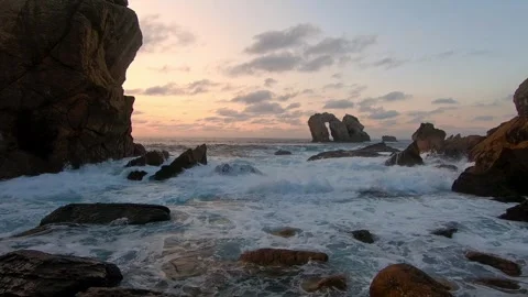 Powerful ocean waves breaking against a rocky coastline at sunset with a na.. Stock Footage 343227516