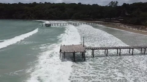 Powerful ocean waves breaking against wooden pier in Bang Bao bay Stock Footage 346504493