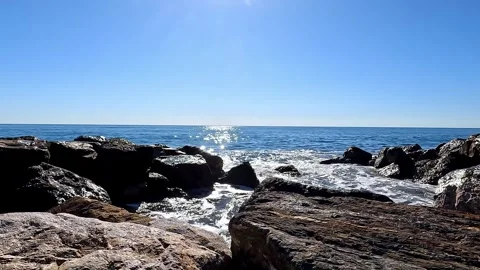 Powerful ocean waves crash against rugged coastal rocks, capturing the energy an Stock Footage 331476370