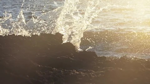 Powerful ocean waves crash dramatically against dark rocky coastal shores. Stock Footage 337411776