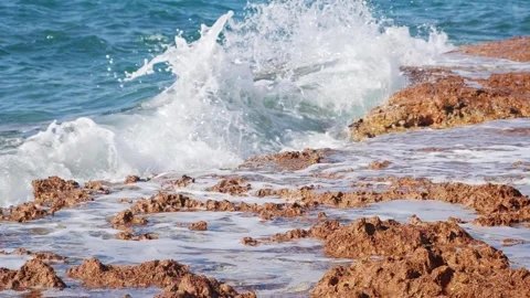 Powerful ocean waves crash splashing onto a rocky coastal shore. Stock Footage 337405709