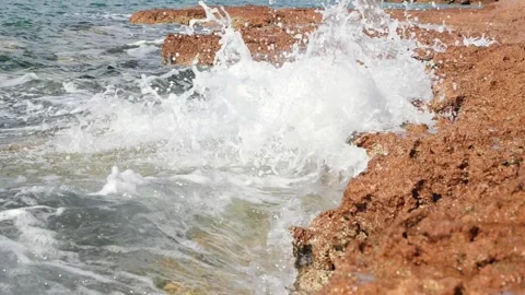 Powerful ocean waves crash violently against the rocky coastal shore Stock Footage 337411357
