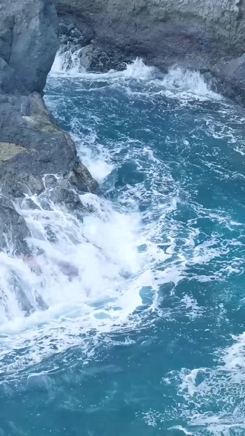 Powerful ocean waves crashing against a rocky cliff Stock Footage 329866036