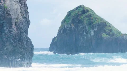 Powerful ocean waves crashing against volcanic rocks Stockbeeldmateriaal 333695495