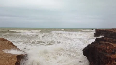 Powerful ocean waves crashing against rocky coastal seascape during daytime Video stock 342076370