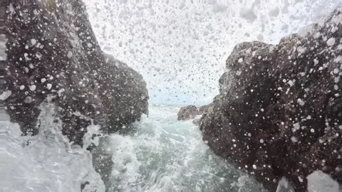 Powerful ocean waves crashing between dark rocky cliffs with sea spray Stock Footage 344900233