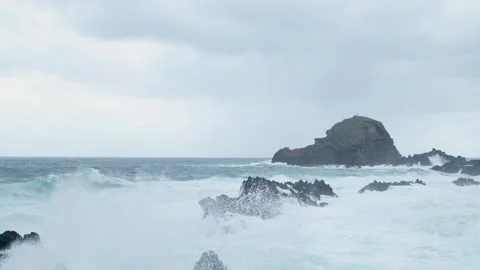 Powerful ocean waves crashing over volcanic rocks in slow motion Stockbeeldmateriaal 333695216