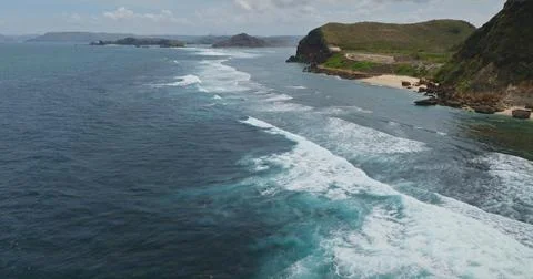 Powerful ocean waves rolling along Bukit Merese coastline Stockfoto's