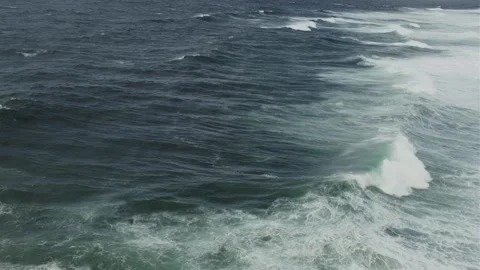 Powerful ocean waves rolling and breaking along a rugged coastline Stockbeeldmateriaal 343131539