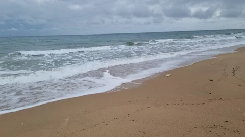 Powerful ocean waves rolling toward shore under dramatic cloudy sky Stock Footage 322040778
