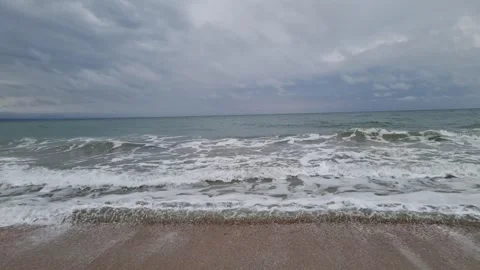 Powerful ocean waves rolling toward shore under dramatic cloudy sky Stock Footage 322040780