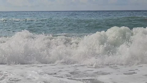 Powerful ocean waves with white foam crash on the beach during a storm. Stock Footage 317578805