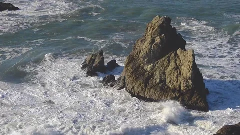 Powerful Pacific Ocean waves crashing against a large ocean sea stack rock Stock Footage 139765373