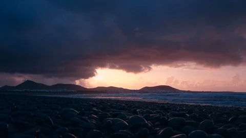 Powerful red sunset sky with stormy clouds near the Famara beach in Lanzarote Stock Footage 89144683