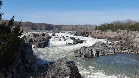 Powerful river rapids flowing through a rocky landscape on a clear day 動画素材 332721109