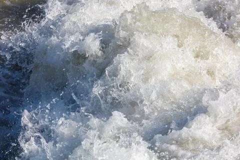 Powerful river rapids with frothy white water and dark blue currents Stock Photos