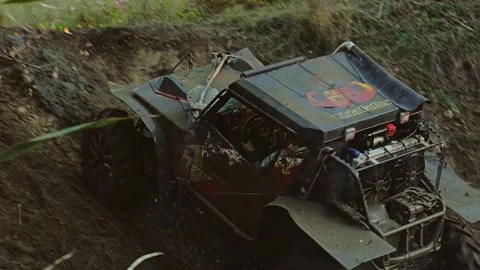 Powerful off-road vehicle covered in mud speeds on a rough course Stock Footage 345496662