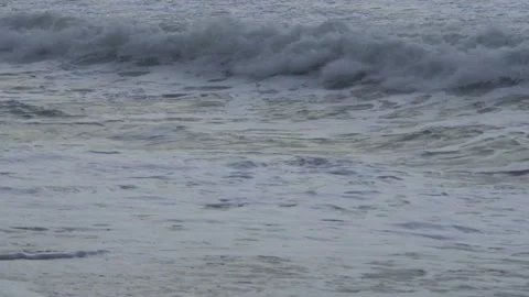 Powerful sea wave splashing on the beach with white foam and sand. Video stock 331488098