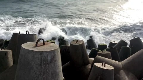 Powerful Sea Waves Breaking into White Foam on Coastal Defense Blocks Stock Footage 333684896