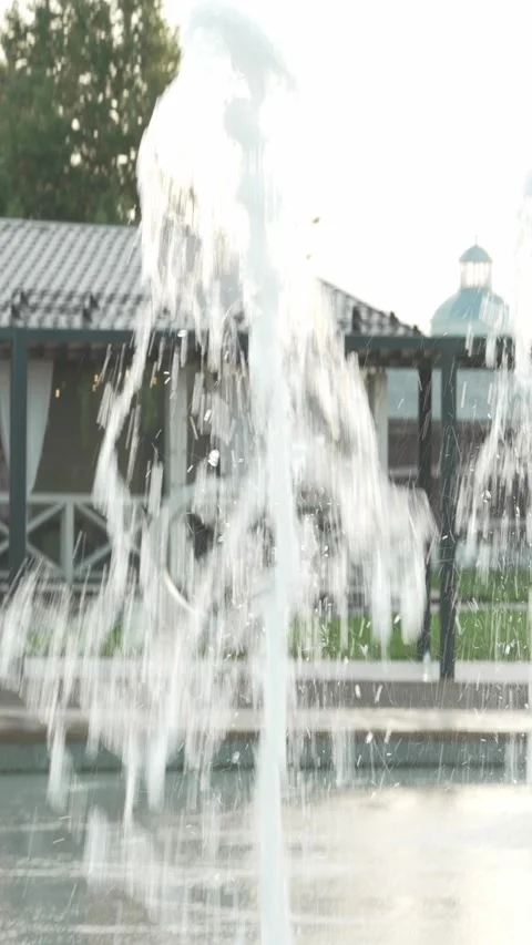 A powerful single jet of water shooting up from a park ground fountain. Stock Footage 341135597