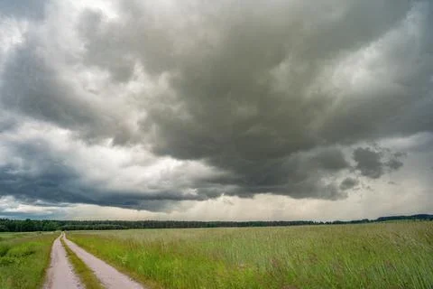Powerful Storm Cloud Over Green Meadow Landscape Stock Photos