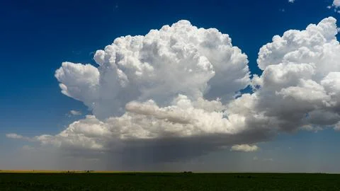 Powerful storm clouds develop, bursting high into the atmosphere with epic te Foto stock