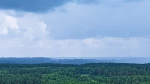 Powerful storm clouds with sunshine flowing above woodland, aerial time lapse Vídeo Stock 315484013
