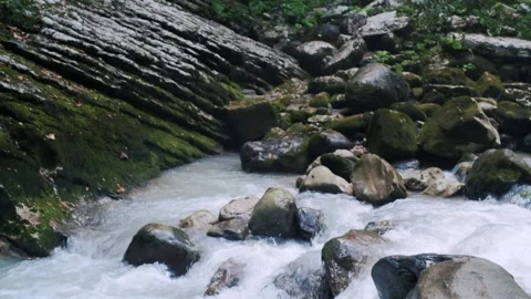 Powerful stream flowing mountain river with huge wet boulders Stock Footage 145842243