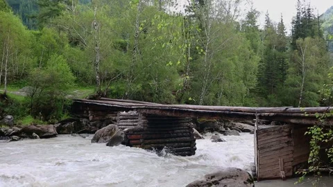 A powerful stream of a mountain river flowing under a bridge between rocks. Stock-Footage 202181561