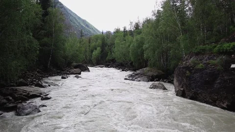 A powerful stream of a mountain river flowing under a bridge between rocks. Stock-Footage 202181590