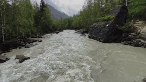 A powerful stream of a mountain river flowing between the rocks. Chuya River Stock Footage 218734852