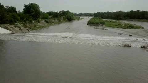 A powerful stream of water tends down the river, overcoming artificial rapids Stock Footage 134685943